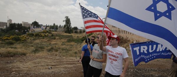 Israelis hold American and Israeli flags with the new U.S. embassy in the background in Jerusalem, Monday, May 14, 2018 - Sputnik International