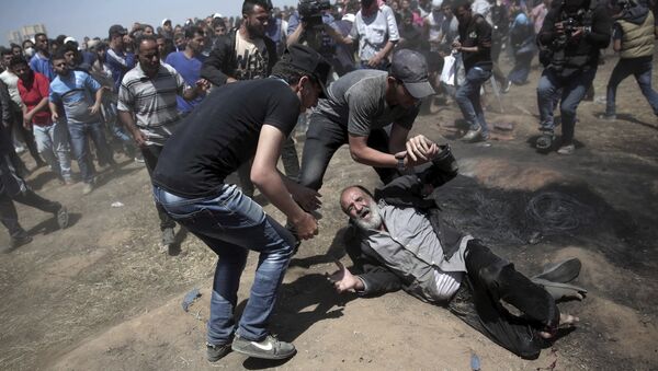 An elderly Palestinian man falls on the ground after being shot by Israeli troops during a deadly protest at the Gaza Strip's border with Israel, east of Khan Younis, Gaza Strip, Monday, May 14, 2018 - Sputnik International