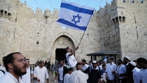 Israelis celebrate as they hold an Israeli flag during a parade marking the annual Jerusalem Day, outside Damascus Gate of Jerusalem's Old City, May 13, 2018 - Sputnik International