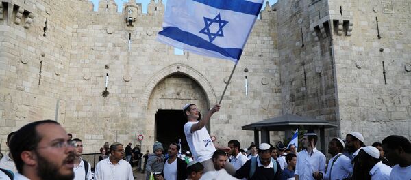 Israelis celebrate as they hold an Israeli flag during a parade marking the annual Jerusalem Day, outside Damascus Gate of Jerusalem's Old City, May 13, 2018 Israelis celebrate as they hold an Israeli flag during a parade marking the annual Jerusalem Day, outside Damascus Gate of Jerusalem's Old City, May 13, 2018 - Sputnik International
