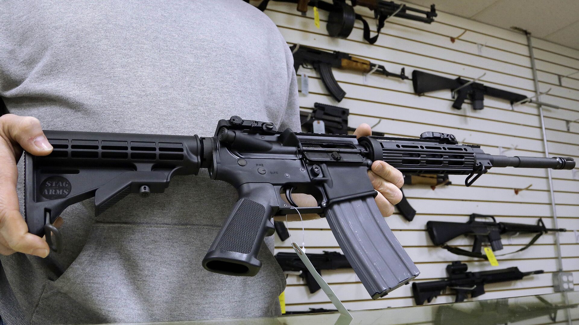 John Jackson, co-owner of Capitol City Arms Supply shows off an AR-15 assault rifle for sale Wednesday, Jan. 16, 2013 at his business in Springfield, Ill.  - Sputnik International, 1920, 30.05.2022