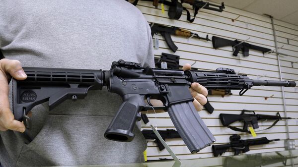 John Jackson, co-owner of Capitol City Arms Supply shows off an AR-15 assault rifle for sale Wednesday, Jan. 16, 2013 at his business in Springfield, Ill.  - Sputnik International