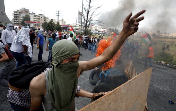 A Palestinian demonstrator gestures during a protest marking the 70th anniversary of Nakba, near the Jewish settlement of Beit El, near Ramallah, in the occupied West Bank May 15, 2018 - Sputnik International