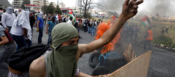 A Palestinian demonstrator gestures during a protest marking the 70th anniversary of Nakba, near the Jewish settlement of Beit El, near Ramallah, in the occupied West Bank May 15, 2018 A Palestinian demonstrator gestures during a protest marking the 70th anniversary of Nakba, near the Jewish settlement of Beit El, near Ramallah, in the occupied West Bank May 15, 2018 - Sputnik International