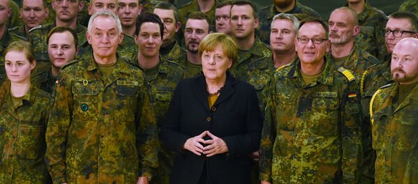 German chancellor Angela Merkel (C) poses next to Surgeon General Michael Tempel (L) and commander Dirk Moellmann (2L) and members of the German army Rapid Medical Response Forces Command in Leer, northern Germany, on December 7, 2015 German chancellor Angela Merkel (C) poses next to Surgeon General Michael Tempel (L) and commander Dirk Moellmann (2L) and members of the German army Rapid Medical Response Forces Command in Leer, northern Germany, on December 7, 2015 - Sputnik International