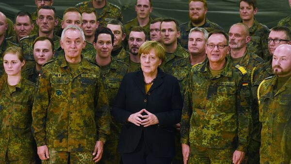 German chancellor Angela Merkel (C) poses next to Surgeon General Michael Tempel (L) and commander Dirk Moellmann (2L) and members of the German army Rapid Medical Response Forces Command in Leer, northern Germany, on December 7, 2015 - Sputnik International