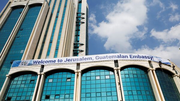 Workers hanging from the side of a building place a banner welcoming the opening of the new Guatemalan embassy in Jerusalem, in the complex hosting the new embassy in Jerusalem, May 15, 2018 - Sputnik International