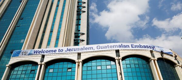 Workers hanging from the side of a building place a banner welcoming the opening of the new Guatemalan embassy in Jerusalem, in the complex hosting the new embassy in Jerusalem, May 15, 2018 - Sputnik International