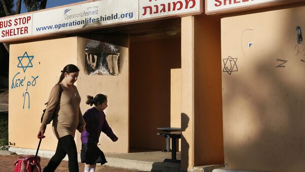 An Israeli mother passes by a bus stop which serves as well as a bomb shelter when she accompanies her girl to school (File) - Sputnik International