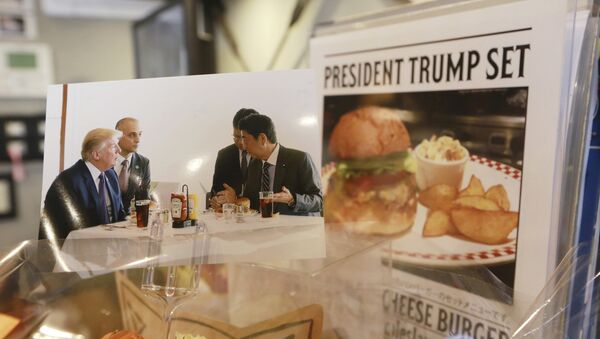 A photo showing U.S. President Donald Trump, left, and Japanese Prime Minister Shinzo Abe, right, at a lunch of hamburgers from Munch's Burger Shack at Kasumigaseki Country Club, is displayed at the burger restaurant in Tokyo Thursday, Nov. 16, 2017 - Sputnik International
