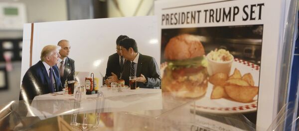 A photo showing U.S. President Donald Trump, left, and Japanese Prime Minister Shinzo Abe, right, at a lunch of hamburgers from Munch's Burger Shack at Kasumigaseki Country Club, is displayed at the burger restaurant in Tokyo Thursday, Nov. 16, 2017 - Sputnik International