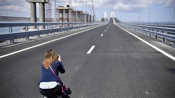 A journalist takes a photograph of the new bridge linking Russia and the Crimean peninsula prior to the opening ceremony near Kerch, Crimea, Tuesday, May 15, 2018 - Sputnik International