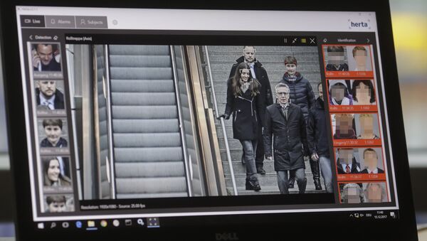 The screen of a computer with an automatic facial recognition system shows German Interior Minister Thomas de Maiziere (2ndR) walking down stairs as he visits the Suedkreuz train station where automatic facial recognition technologies are tested on December 15, 2017 in Berlin - Sputnik International