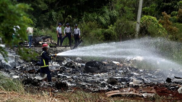 Firefighters work in the wreckage of a Boeing 737 plane that crashed in the agricultural area of Boyeros, around 20 km (12 miles) south of Havana, shortly after taking off from Havana's main airport in Cuba, May 18, 2018. - Sputnik International