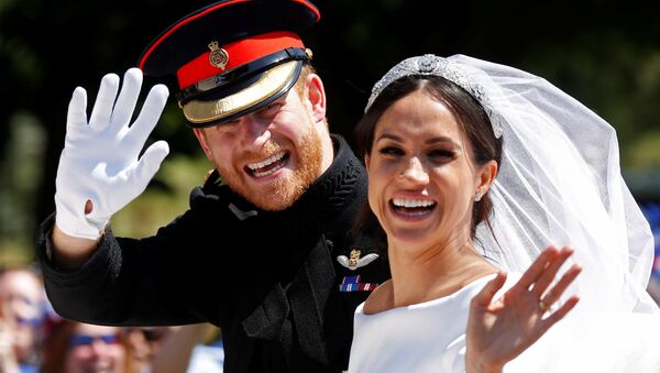 Britain’s Prince Harry and his wife Meghan wave as they ride a horse-drawn carriage after their wedding ceremony at St George’s Chapel in Windsor Castle in Windsor, Britain, May 19, 2018 - Sputnik International