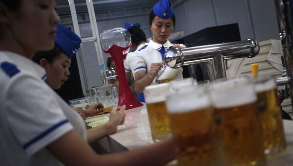 A waitress fill up jugs of beer during Taedonggang Beer Festival in Pyongyang, North Korea, Sunday, Aug. 21, 2016. - Sputnik International