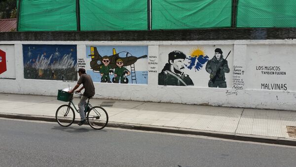 A man cycles past a mural about the Malvinas War on the wall of a military base in Buenos Aires - Sputnik International