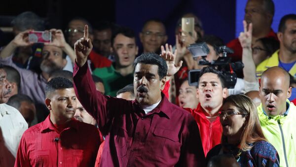 Venezuela's President Nicolas Maduro raises a finger as he is surrounded by supporters while speaking during a gathering after the results of the election were released, outside of the Miraflores Palace in Caracas, Venezuela, May 20, 2018 - Sputnik International