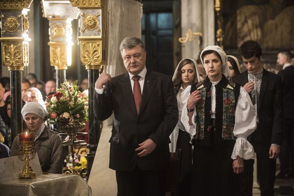 Ukrainian President Petro Poroshenko, center, and his wife Maryna Poroshenko, right, cross themselves during Orthodox Easter celebrating in the Volodymyrskiy Monastery in Kiev, Ukraine, Sunday, April 8, 2018 - Sputnik International