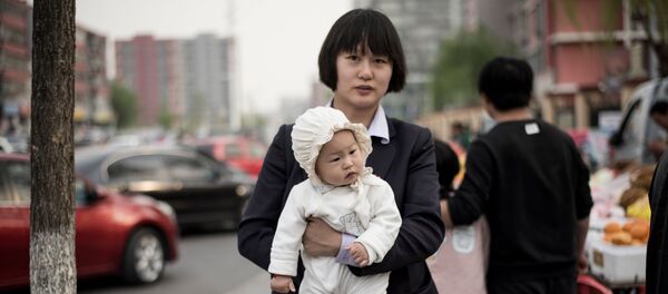 A mother holds her baby as she walks in a market in Shunyi on the outskirts of Beijing on April 13, 2017 A mother holds her baby as she walks in a market in Shunyi on the outskirts of Beijing on April 13, 2017 - Sputnik International