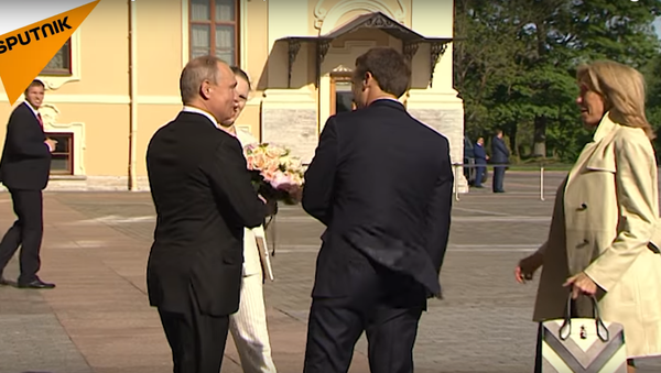 Putin giving flowers to the French First Lady, May 24, 2018 - Sputnik International