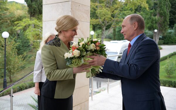 President Putin giving Croatian President Kolinda Grabar-Kitarovic a bouquet during her visit to Russia, October 2017. - Sputnik International