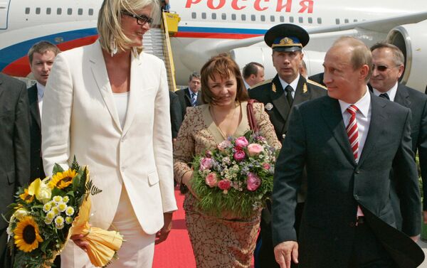Austrian Foreign Minister Ursula Plassnik (left) holds her sunflower bouquet, with Russian President Vladimir Putin and his wife Lyudmila walking alongside her after meeting at Vienna's airport - Sputnik International