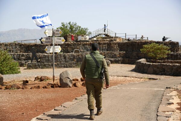 An Israeli soldier walks in an old military outpost, used for visitors to view the Israeli controlled Golan Heights, near the border with Syria, Thursday, May 10, 2018 An Israeli soldier walks in an old military outpost, used for visitors to view the Israeli controlled Golan Heights, near the border with Syria, Thursday, May 10, 2018 - Sputnik International
