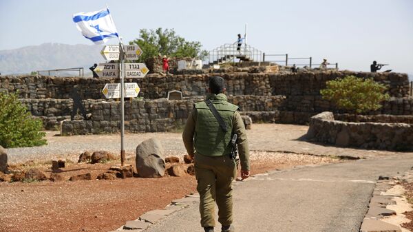 An Israeli soldier walks in an old military outpost, used for visitors to view the Israeli controlled Golan Heights, near the border with Syria, Thursday, May 10, 2018 - Sputnik International