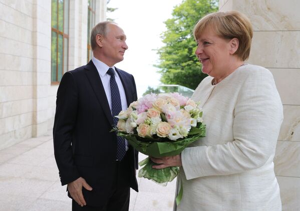 German Chancellor Angela Merkel with bouquet from Vladimir Putin - Sputnik International