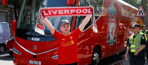 Soccer Football - Champions League - Fans In Kiev Ahead Of The Champions League Final - Kiev, Ukraine - May 25, 2018 Liverpool fan poses with a scarf in front of the team bus - Sputnik International