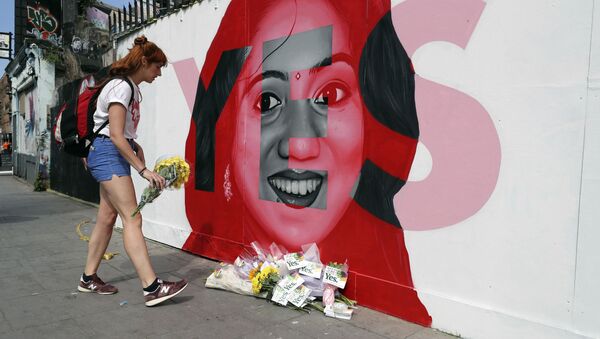A woman places flowers by a mural showing Savita Halappanavar, a 31-year-old Indian dentist who had sought and been denied an abortion before she died after a miscarriage in a Galway hospital, with the word YES over it, in Dublin, Ireland, on the day of a referendum on the 8th amendment of the constitution. - Sputnik International