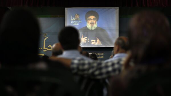 Hezbollah leader Sheik Hassan Nasrallah speaks on a screen via a video link during a ceremony to mark the second anniversary of the death of Hezbollah top commander, Mustafa Badreddine, who was killed in an explosion in Damascus, in the southern suburbs of Beirut, Lebanon, Monday, May 14, 2018 - Sputnik International