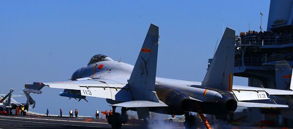 This photo taken on April 24, 2018 shows a J15 fighter jet landing on China's sole operational aircraft carrier, the Liaoning, during a drill at sea This photo taken on April 24, 2018 shows a J15 fighter jet landing on China's sole operational aircraft carrier, the Liaoning, during a drill at sea - Sputnik International