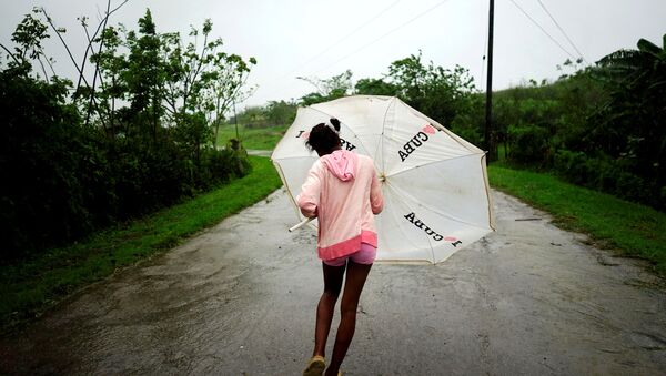 Dalma Samora, 14, walks against the winds of Subtropical Storm Alberto as it passes by the west coast of Cuba, in La Palma, Cuba, May 26, 2018. - Sputnik International
