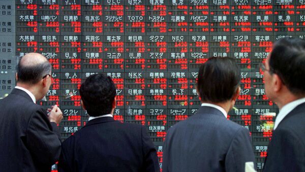 Japanese businessmen stop in front of an electronic board flashing share prices in downtown Tokyo (File) - Sputnik International