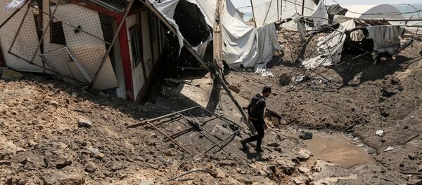 A man inspects the damage at a site targeted by an Israeli air strike a day before in Khan Younis in the southern Gaza strip on May 30, 2018 - Sputnik International