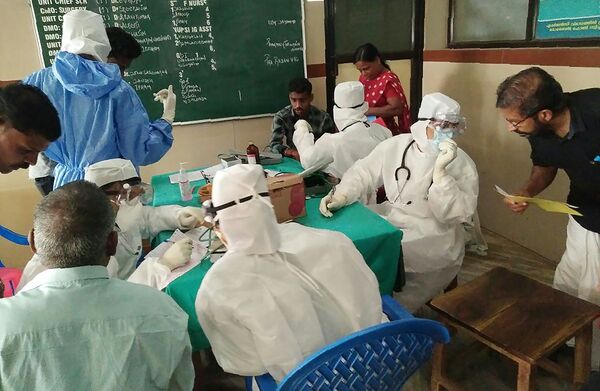 Medical personnel wearing protective suits check patients at the Medical College hospital in Kozhikode on May 21, 2018 - Sputnik International