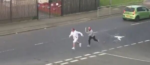 A man wielding a sword chasing another man down a road in Glasgow A man wielding a sword chasing another man down a road in Glasgow - Sputnik International