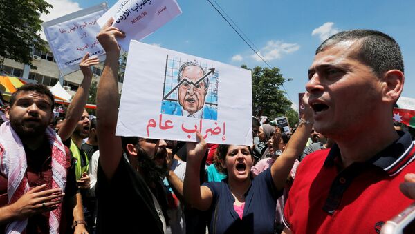 A Jordanian protester holds a picture of Jordanian Prime Ministers Hani al-Mulki and chants slogans during a strike against the new income tax law, in Amman, Jordan May 30, 2018 - Sputnik International