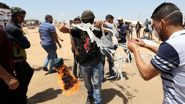 Palestinian demonstrators prepare to set a kite on fire to be thrown at the Israeli side during a protest demanding the right to return to their homeland, at the Israel-Gaza border in the southern Gaza Strip, May 11, 2018 - Sputnik International