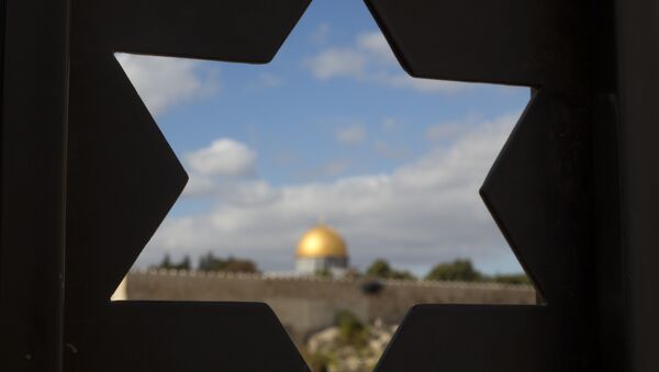 The Dome of the Rock Mosque in the Al-Aqsa Mosque compound in Jerusalem's Old City is seen through a door with the shape of star of David. - Sputnik International
