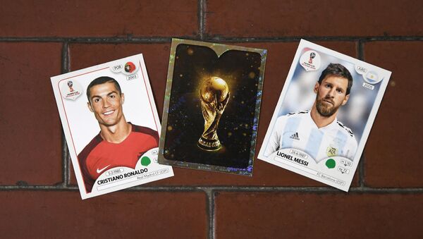 This photo taken on April 20, 2018 shows collectible cards featuring (L-R) Portugal's forward Cristiano Ronaldo, the Fifa World Cup Trophy and Argentina's forward Lionel Messi as part of a series featuring players for the 2018 Russia football World Cup at the Panini Group factory in Modena, northern Italy - Sputnik International