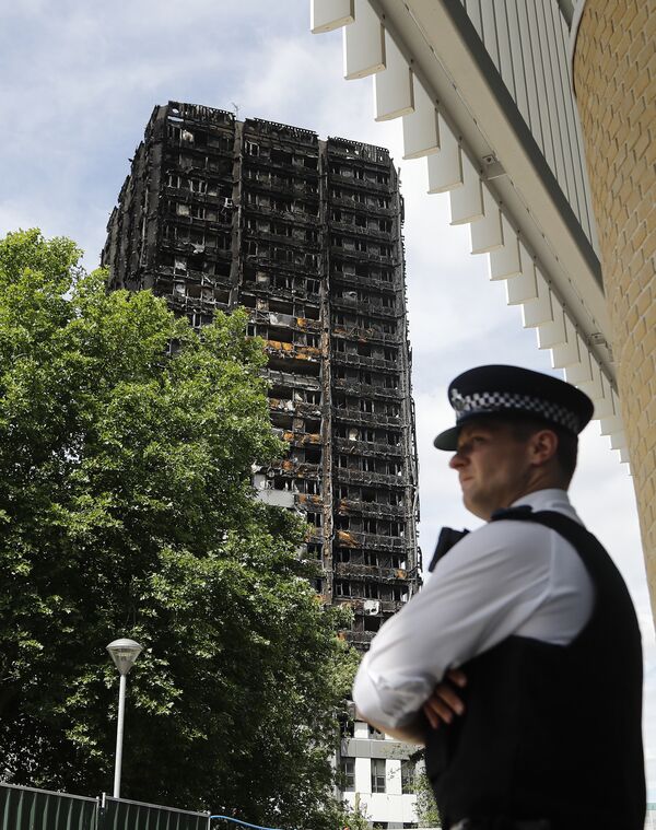 A police officer stands near to the burnt Grenfell Tower apartment building standing testament to the recent fire in London, Friday, June 23, 2017. A police officer stands near to the burnt Grenfell Tower apartment building standing testament to the recent fire in London, Friday, June 23, 2017. - Sputnik International