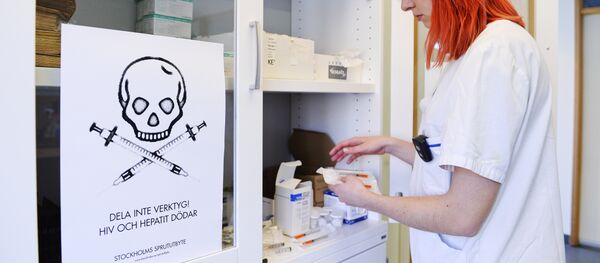 A nurse prepares a kit for drug addicts next to a sign that reads  Do not share tools! HIV and Hepatitis kills at the needle exchange facility located in St Goeran's hospital in Stockholm on April 2, 2014 - Sputnik International