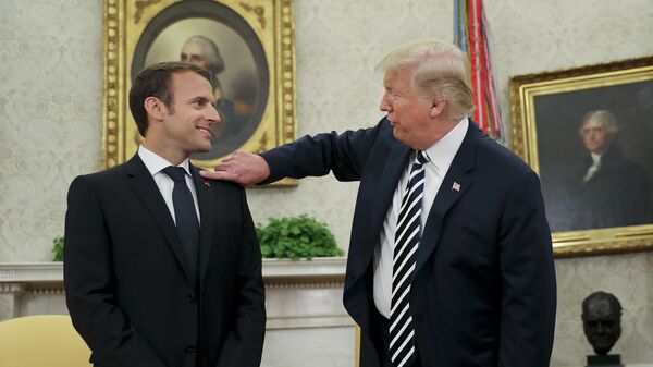 President Donald Trump playfully reaches over to cleans lint off French President Emmanuel Macron's suit jacket during their meeting in Oval Office of the White House in Washington, Tuesday, April 24, 2018 - Sputnik International