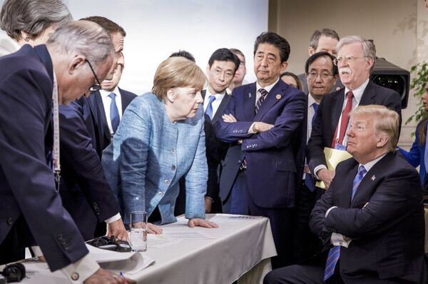 German Chancellor Angela Merkel, center, details policy to US President Donald Trump, seated at right, during the G7 Leaders Summit in La Malbaie, Quebec, Canada, on Saturday, June 9, 2018 German Chancellor Angela Merkel, center, details policy to US President Donald Trump, seated at right, during the G7 Leaders Summit in La Malbaie, Quebec, Canada, on Saturday, June 9, 2018 - Sputnik International