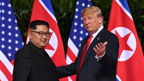 US President Donald Trump (R) gestures as he meets with North Korea's leader Kim Jong Un (L) at the start of their historic US-North Korea summit, at the Capella Hotel on Sentosa island in Singapore on June 12, 2018. - Sputnik International