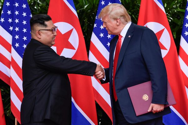 U.S. President Donald Trump and North Korea's leader Kim Jong Un shake hands during the signing of a document after their summit at the Capella Hotel on Sentosa island in Singapore June 12, 2018 U.S. President Donald Trump and North Korea's leader Kim Jong Un shake hands during the signing of a document after their summit at the Capella Hotel on Sentosa island in Singapore June 12, 2018 - Sputnik International