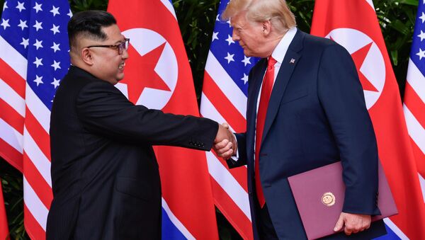 U.S. President Donald Trump and North Korea's leader Kim Jong Un shake hands during the signing of a document after their summit at the Capella Hotel on Sentosa island in Singapore June 12, 2018 - Sputnik International